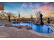 Inviting pool features a rock waterfall and spillover spa surrounded by lush landscaping at 8320 E Arroyo Hondo Rd, Scottsdale, AZ 85266