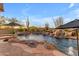 Pool with waterfall features, desert landscaping and lounge umbrellas at 8320 E Arroyo Hondo Rd, Scottsdale, AZ 85266