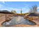 Pool with waterfall features, desert landscaping and lounge umbrellas at 8320 E Arroyo Hondo Rd, Scottsdale, AZ 85266