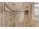 Close up of the tiled shower featuring duel shower heads, a niche for toiletries, and glass block for light at 8320 E Arroyo Hondo Rd, Scottsdale, AZ 85266