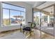 Sitting area with a patterned chair, marble floors, a glass sliding door, and a large window with an outdoor view at 8320 E Arroyo Hondo Rd, Scottsdale, AZ 85266