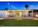 Lush backyard with a covered patio, lounge seating, a ping pong table, and outdoor lighting at 8640 E Dianna Dr, Scottsdale, AZ 85254