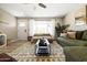 Cozy living room with a decorative rug, modern coffee table, and a comfortable green sofa beneath a ceiling fan at 8640 E Dianna Dr, Scottsdale, AZ 85254