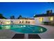 Swimming pool lit up at twilight is surrounded by lounge chairs for relaxation at 8640 E Dianna Dr, Scottsdale, AZ 85254