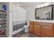 Bathroom featuring a shower/tub combo, wood vanity, and storage shelves at 9005 E Grandview Dr, Mesa, AZ 85207