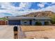 Single-story home featuring desert landscaping and a mountain in the background under a cloudy, blue sky at 9005 E Grandview Dr, Mesa, AZ 85207