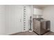 Bright laundry room with a washer, dryer, white cabinets, and painted brick accents at 9005 E Grandview Dr, Mesa, AZ 85207