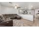 Open-concept kitchen and living room featuring hardwood floors, a gray sofa, and white walls under recessed lighting at 9005 E Grandview Dr, Mesa, AZ 85207