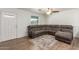 Cozy living room with a gray sectional sofa, wood-look flooring, ceiling fan, and lots of natural light at 9005 E Grandview Dr, Mesa, AZ 85207