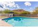 Beautiful in-ground pool featuring clear blue water and a blue patio set, set against a backdrop of desert foliage at 9005 E Grandview Dr, Mesa, AZ 85207