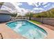 Inviting in-ground pool with clear blue water, complemented by a blue patio set and desert landscaping at 9005 E Grandview Dr, Mesa, AZ 85207