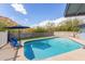 Sparkling in-ground pool, perfect for summer days, complemented by a blue patio set and lush greenery at 9005 E Grandview Dr, Mesa, AZ 85207