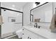 Modern bathroom featuring a sleek glass-enclosed shower and elegant vanity with black hardware, creating a serene retreat at 9739 E Pershing Ave, Scottsdale, AZ 85260