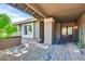 Inviting entryway featuring a stone and gravel path and a covered porch with decorative pillars and double doors at 9739 E Pershing Ave, Scottsdale, AZ 85260