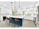 Open kitchen with island, barstool seating, white cabinets, and stainless appliances, perfect for entertaining at 9739 E Pershing Ave, Scottsdale, AZ 85260