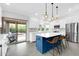 Modern kitchen with island seating, pendant lighting, stainless steel appliances, and a view of the backyard at 9739 E Pershing Ave, Scottsdale, AZ 85260