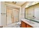 Bathroom with a walk in shower, wood cabinets, and a large mirror above the sink at 9813 W Pleasant Valley Rd, Sun City, AZ 85351