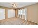 Neutral bedroom with a ceiling fan, tan walls, carpet flooring, and bright windows at 9813 W Pleasant Valley Rd, Sun City, AZ 85351