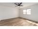 Light-filled bedroom with wood-look flooring, a modern ceiling fan, and a large window at 1021 S Greenfield Rd # 1001, Mesa, AZ 85206