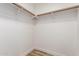 Walk-in closet features ample storage space with painted wooden rails and shelf supports at 1021 S Greenfield Rd # 1001, Mesa, AZ 85206
