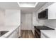 Modern kitchen with white cabinets, quartz countertops, stainless steel appliances, and new wood-look floors at 1021 S Greenfield Rd # 1001, Mesa, AZ 85206