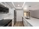 Well-lit kitchen showcasing white cabinets, stainless steel appliances, a breakfast bar and wood-look flooring at 1021 S Greenfield Rd # 1001, Mesa, AZ 85206