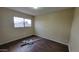 Neutral bedroom featuring wood-look floors, light walls, and a sunlit window at 11602 W Sage Dr, Avondale, AZ 85392