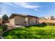 Manicured backyard with lush green lawn, covered patio, and mature trees for privacy at 1250 E Vermont Dr, Gilbert, AZ 85295