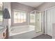 Bathroom with a soaking tub and shower with glass door, window, and granite countertop at 1250 E Vermont Dr, Gilbert, AZ 85295