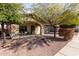 Inviting single-story home with desert landscaping, mature trees, and a covered front porch at 1250 E Vermont Dr, Gilbert, AZ 85295