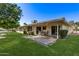 Expansive backyard featuring a covered patio, lush green lawn, and well-maintained landscaping at 12633 W Brandywine Dr, Sun City West, AZ 85375