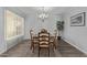 Formal dining room with chandelier, wood floors, and a large window with vertical blinds at 12633 W Brandywine Dr, Sun City West, AZ 85375