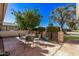 This cozy patio has a table, chairs, and a privacy wall with lush landscaping at 12633 W Brandywine Dr, Sun City West, AZ 85375