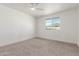 This bedroom features neutral carpet, a ceiling fan, and a window at 1318 E Mission Grande Ave, Casa Grande, AZ 85122