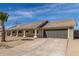 Well-maintained single-story home with desert landscaping, a tiled roof, and an attached two-car garage at 1318 E Mission Grande Ave, Casa Grande, AZ 85122