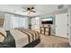 Comfortable bedroom with a ceiling fan, neutral tones, and a sliding barn door to the en-suite bathroom at 13307 W Paso Trl, Peoria, AZ 85383