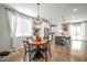 Dining area featuring a modern chandelier, wood table, and views into the kitchen at 13307 W Paso Trl, Peoria, AZ 85383