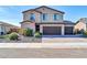 Two-story home featuring a three-car garage, desert landscaping, and a welcoming front entrance at 13307 W Paso Trl, Peoria, AZ 85383