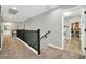 Upstairs hallway with carpet and black railing, leading to laundry room and bathroom at 13307 W Paso Trl, Peoria, AZ 85383