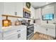 Well-appointed kitchen featuring white cabinetry, stainless steel appliances, and stylish backsplash at 13307 W Paso Trl, Peoria, AZ 85383