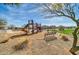 Community playground with a slide and climbing structure surrounded by mulch and grassy areas at 13307 W Paso Trl, Peoria, AZ 85383