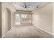 Bright bedroom with a ceiling fan, a window and a door to the outdoor providing ample natural light at 14575 W Mountain View Blvd # 11221, Surprise, AZ 85374