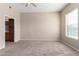 Neutral bedroom features a ceiling fan, carpet and large window for ample natural lighting at 14575 W Mountain View Blvd # 11221, Surprise, AZ 85374