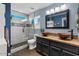 Bright bathroom featuring a shower with glass door, dual sinks, framed mirror, and modern fixtures at 1531 S Owl Dr, Gilbert, AZ 85296