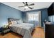 Comfortable bedroom featuring a ceiling fan, wood floors, and ample natural light from the window at 1531 S Owl Dr, Gilbert, AZ 85296