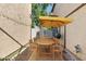 Outdoor dining area with a large table, seating for six, and a yellow sun umbrella at 1531 S Owl Dr, Gilbert, AZ 85296