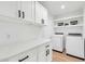 Well-organized laundry room with modern washer/dryer, ample counter space, and plenty of storage cabinets at 15609 N 59Th St, Scottsdale, AZ 85254