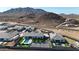 An aerial view showcases a stunning desert home with a private pool, tennis court, and mountain views at 16832 E Hazeltine Way, Queen Creek, AZ 85142