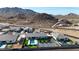 An aerial view showcases a stunning desert home with a private pool, tennis court, and mountain views at 16832 E Hazeltine Way, Queen Creek, AZ 85142