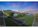 Expansive backyard features a built-in trampoline, lush turf, mature landscaping and sports court for active play at 16832 E Hazeltine Way, Queen Creek, AZ 85142